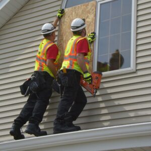 crew boarding up window on a house - 24/7 emergency services for board up of a house