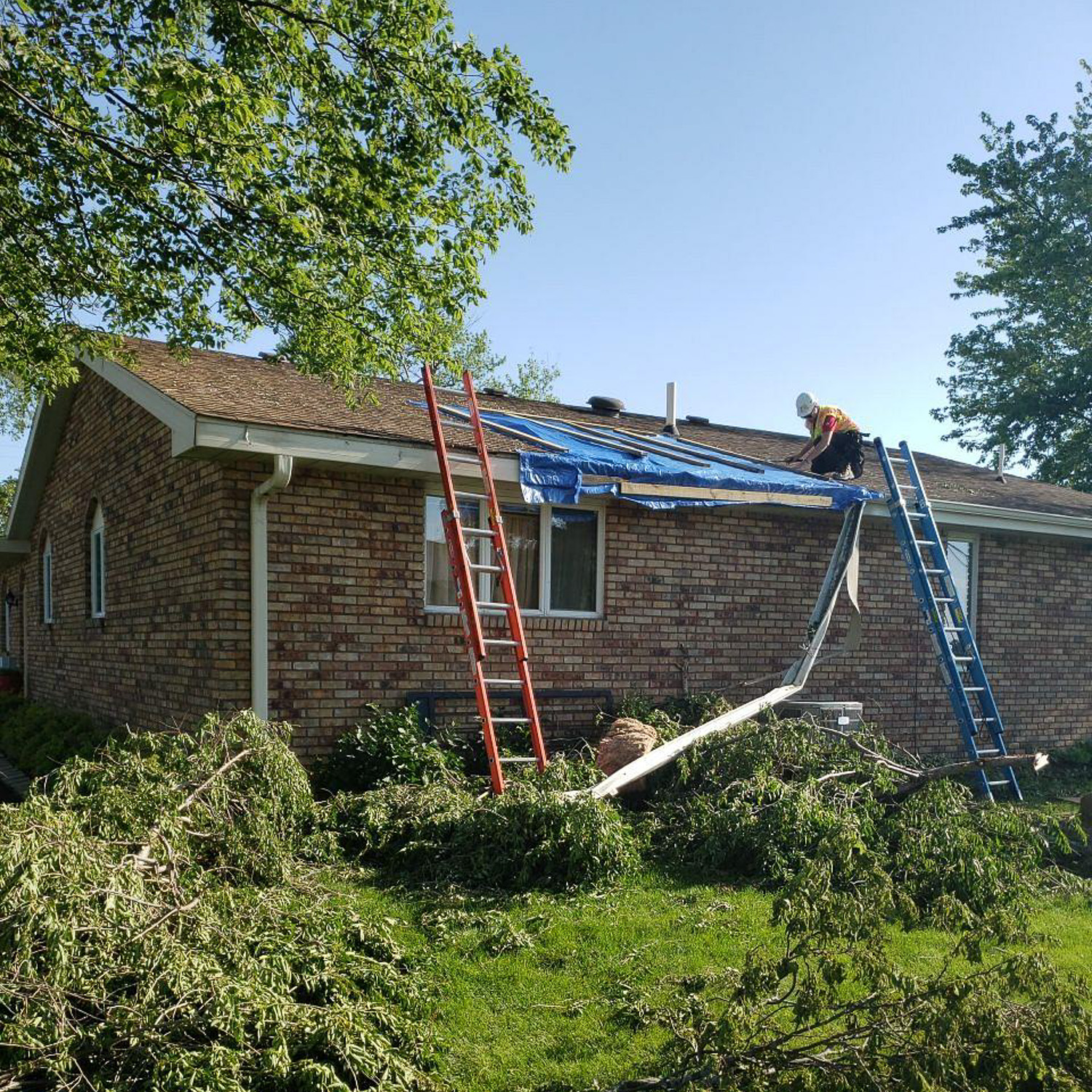 roof being boarded up and tarped after storm damage